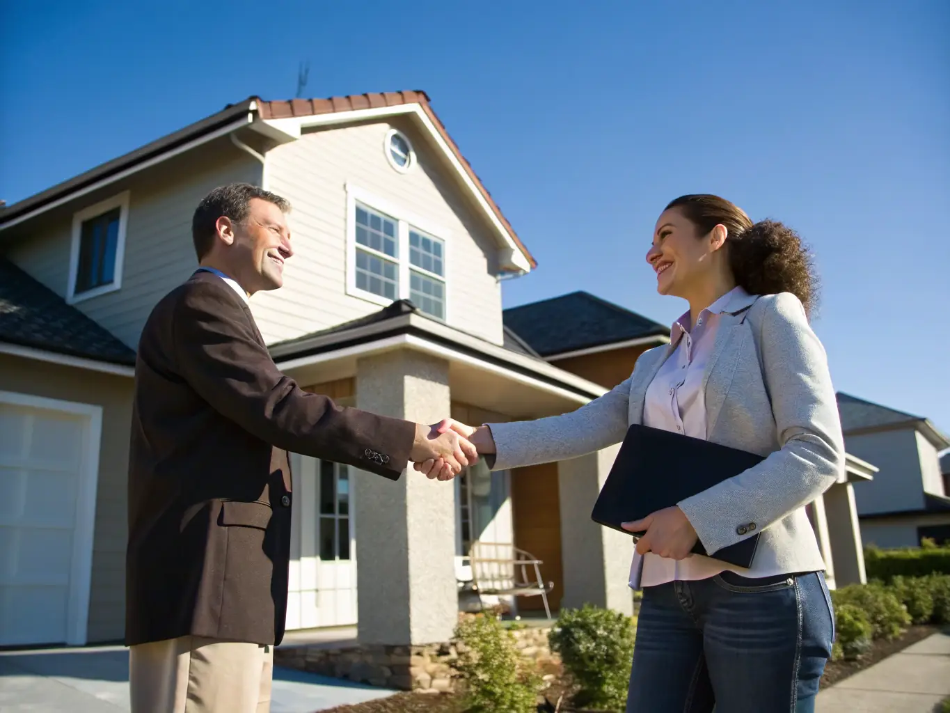 An image of a real estate agent shaking hands with a client, symbolizing trust, partnership, and a commitment to client satisfaction.